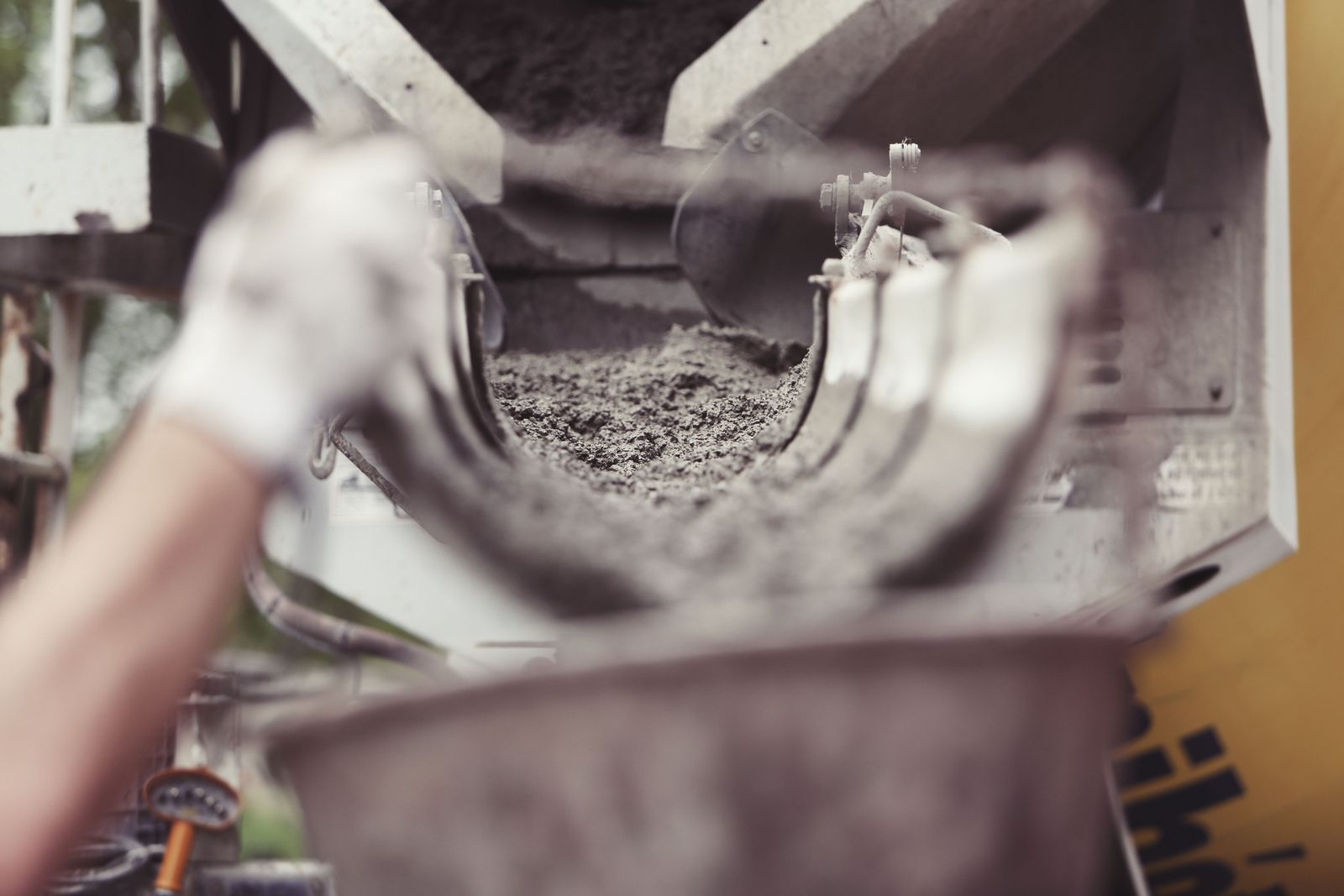 Wet concrete running down a mixer truck chute into a wheelbarrow on site